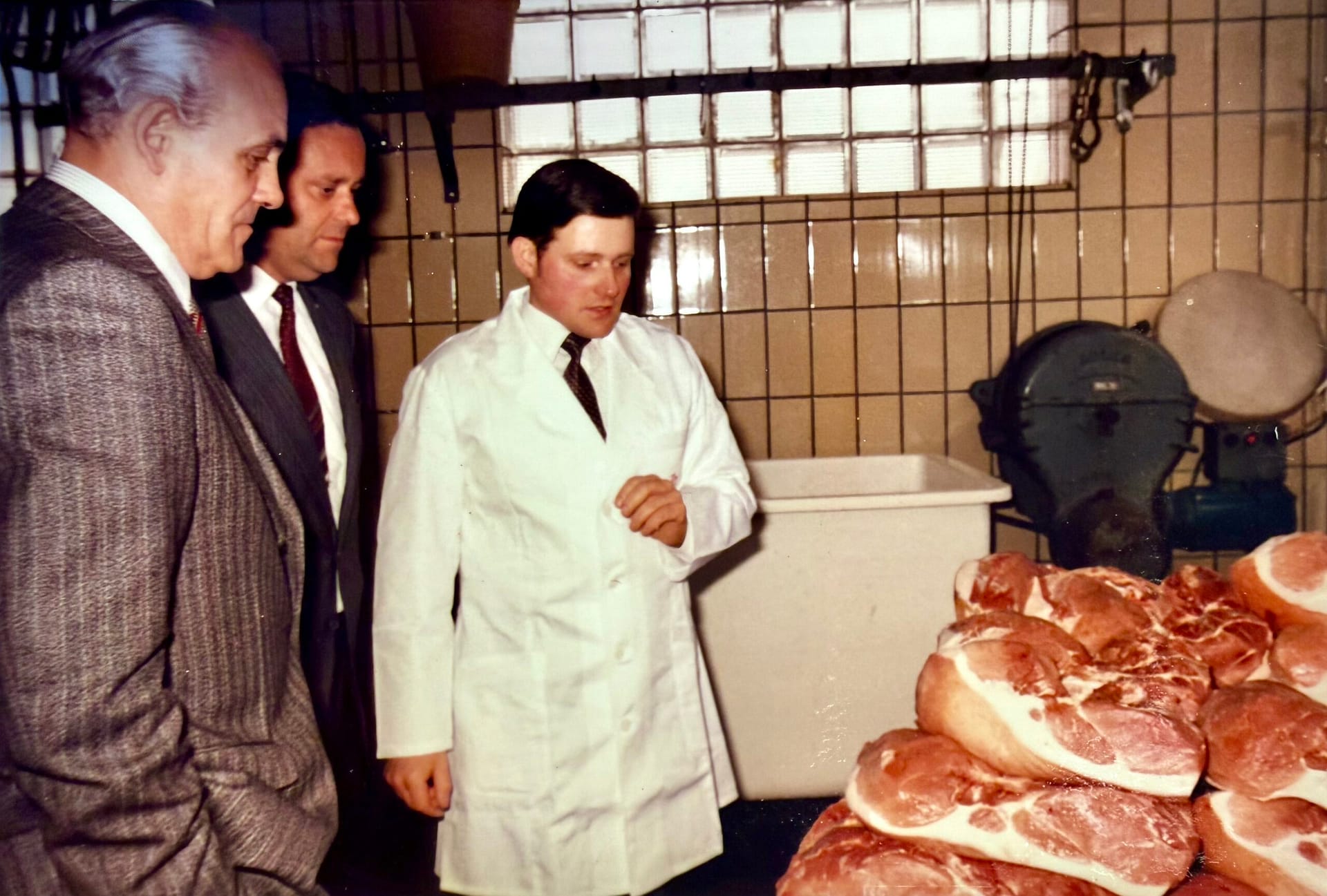 Historisches Foto: Rolf Decker erläutert Hermann Viellieber und Bürgermeister Manfred Kienzle die Qualität seiner Schinken, 1977